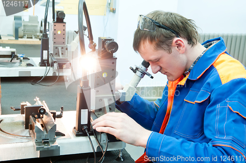 Image of laborer checking tool with optical device