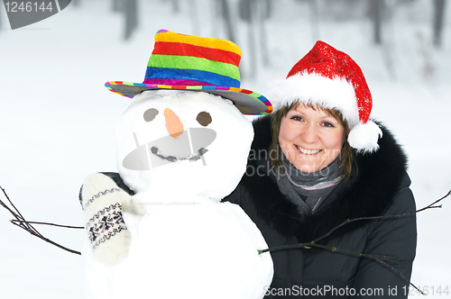 Image of happy girl and snowman in winter