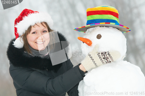 Image of happy girl and snowman in winter