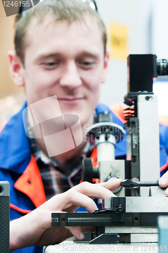 Image of laborer checking tool with optical device