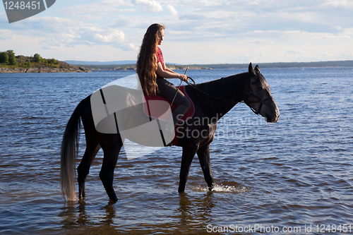 Image of A girl with flowing hair on a horse