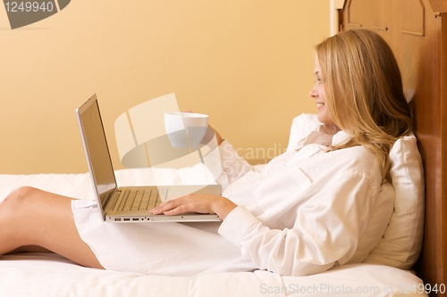Image of Happy Girl in Bed Using a Laptop Computer