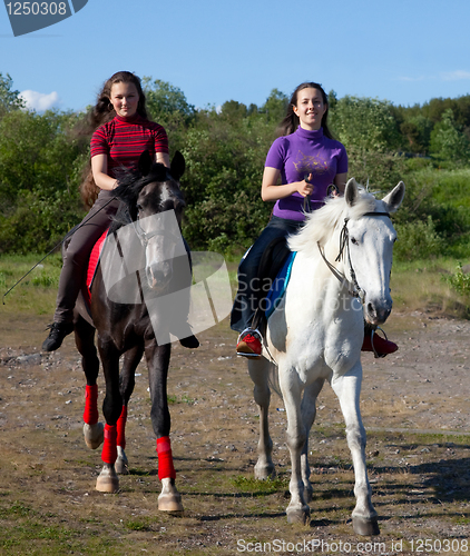 Image of Two girls walking on horseback