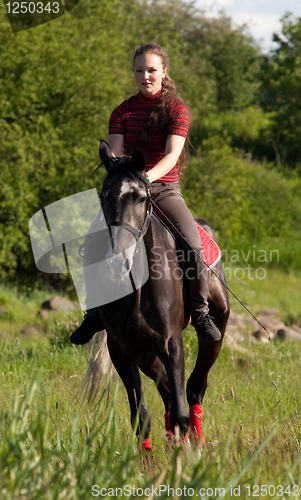 Image of A girl riding a horse at a gallop