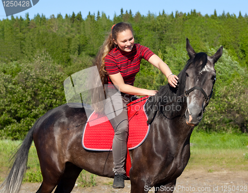 Image of A girl with her hair stroking horse