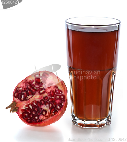 Image of Half of pomegranate fruit and glass with juice