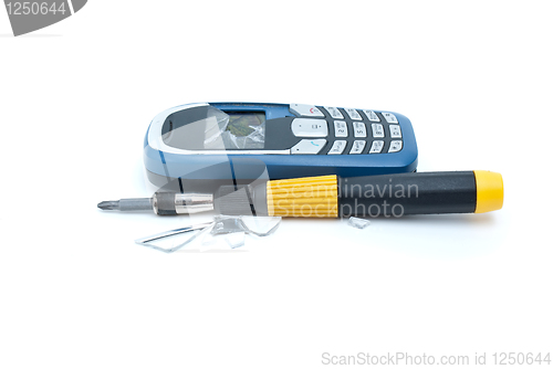 Image of Broken cellular phone and screwdriver