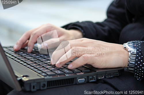 Image of Hands typing on laptop computer keyboard close up