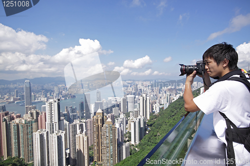 Image of Tourist taking photo of Hong Kong skyline by his digital camera 