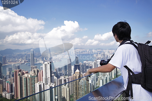 Image of Tourist taking photo of Hong Kong skyline by his digital camera 