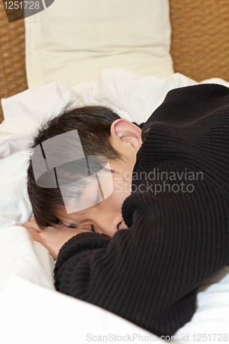 Image of Man comfortably sleeping in his bed 