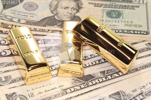 Image of three gold bars on dollar bills