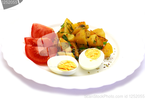 Image of Eggs laying next to potatoes and tomatoes