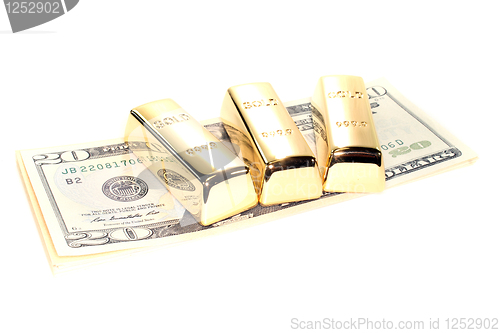 Image of three gold bars on dollar bills