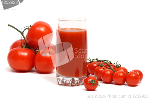 Image of A glass of tomato juice on a background of ripe tomatoes.