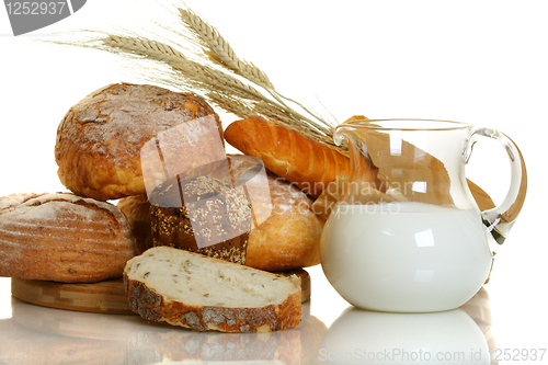 Image of Fresh bread and milk in a glass jar.
