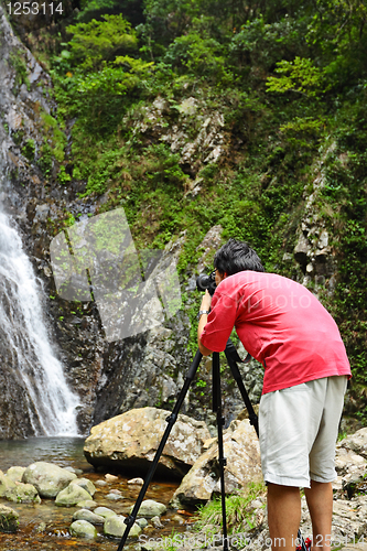 Image of photographer taking picture of waterfall