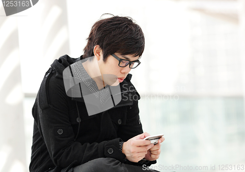 Image of man sms on cell phone