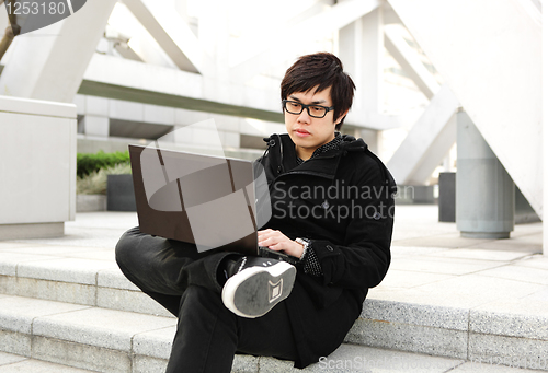 Image of man using computer outdoor