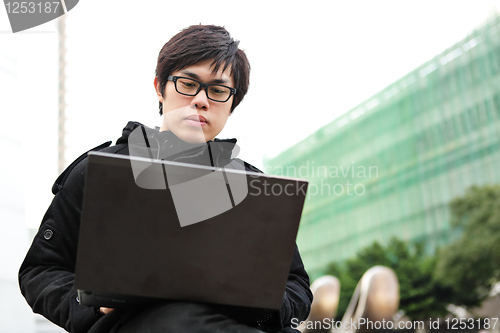 Image of man using computer outdoor