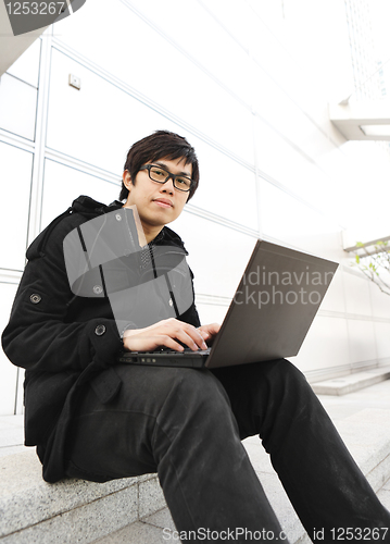 Image of man using computer outdoor