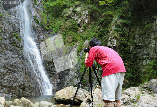 Image of photographer taking picture of waterfall