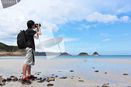 Image of Photographer taking photo on beach