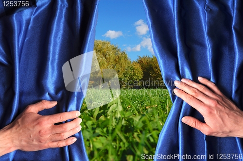 Image of landscape behind blue curtain