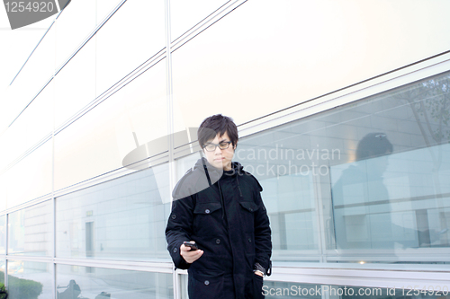 Image of Business man using cellphone when waiting in station. 