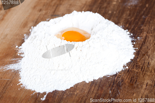 Image of broken egg on flour