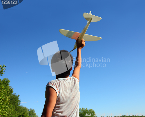 Image of boy running airplane model