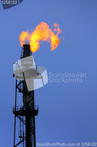 Image of torch is lit on tower refinery