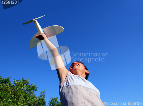 Image of boy running airplane model