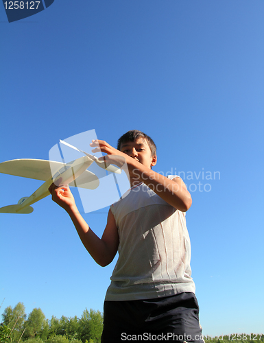 Image of boy running airplane model
