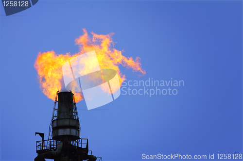 Image of torch is lit on tower refinery