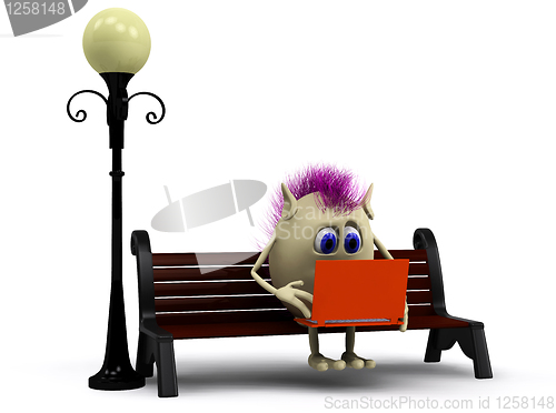 Image of Haired puppet using orange laptop on bench