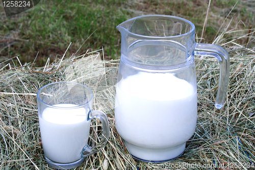 Image of Foto of milk and glass on haystack