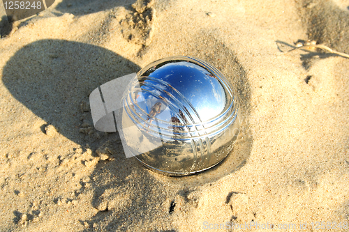 Image of Foto of ball on sand reflecting sky