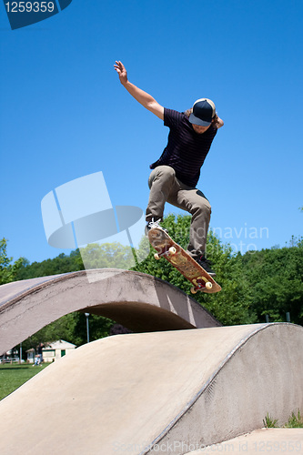 Image of Skateboarder Doing a Jump at a Concrete Skate Park