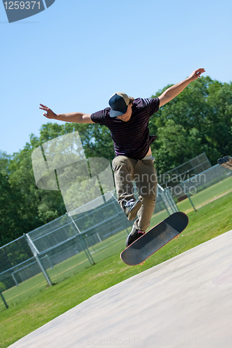 Image of Skateboarder Doing Tricks On His Board