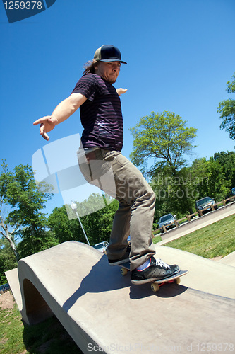 Image of Skateboarder Rail Grinding at a Concrete Skate Park