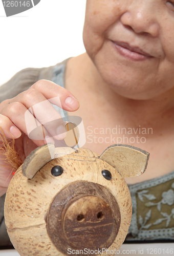 Image of woman putting coins in small piggy bank. Selective focus, Copy s