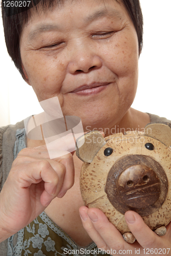 Image of woman putting coins in small piggy bank. Selective focus, Copy s