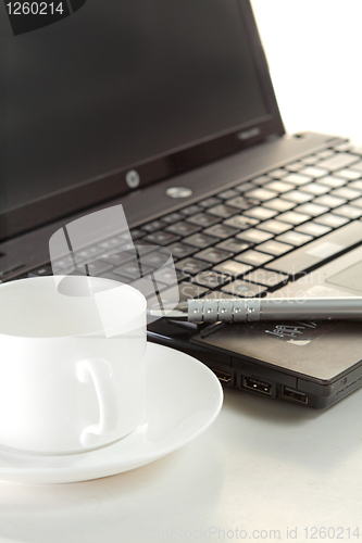 Image of A cup of coffee and a pen on a laptop 