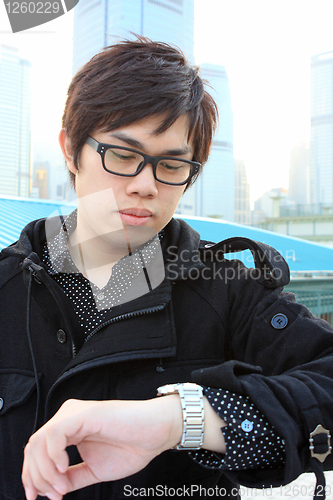 Image of Portrait of a happy young business man checking time 
