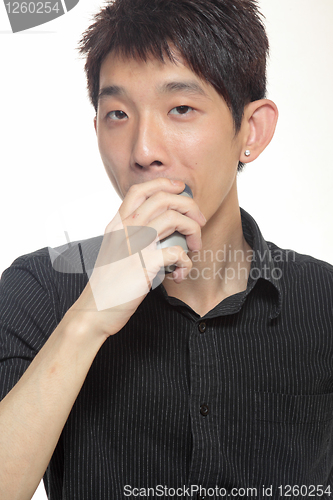 Image of young man shaving his beard off with an electric shaver 