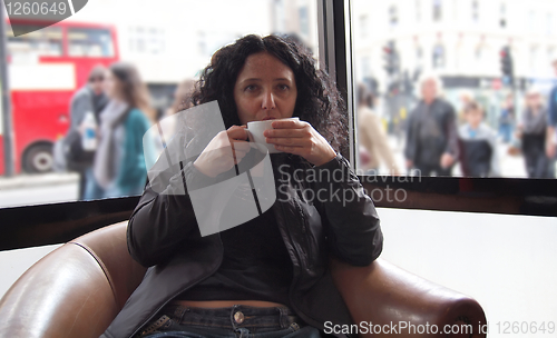 Image of Pretty brunette drinking coffee tea