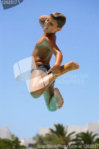 Image of boy jumping into the pool smiling 