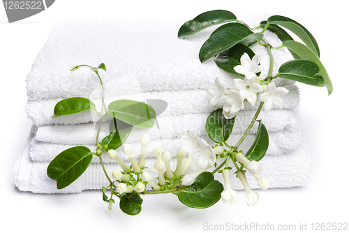 Image of White towels  with white flowers for wellness 