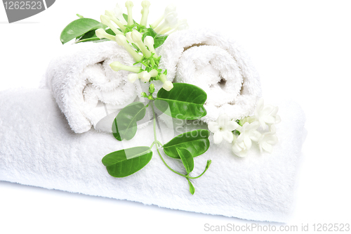 Image of White towels  with white flowers for wellness 
